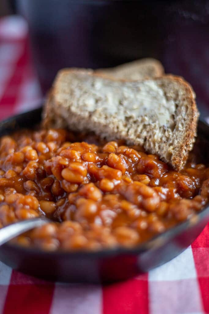 Baked beans in cast iron skillet with buttered bread