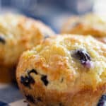 3 lemon blueberry muffins on blue and white napkin