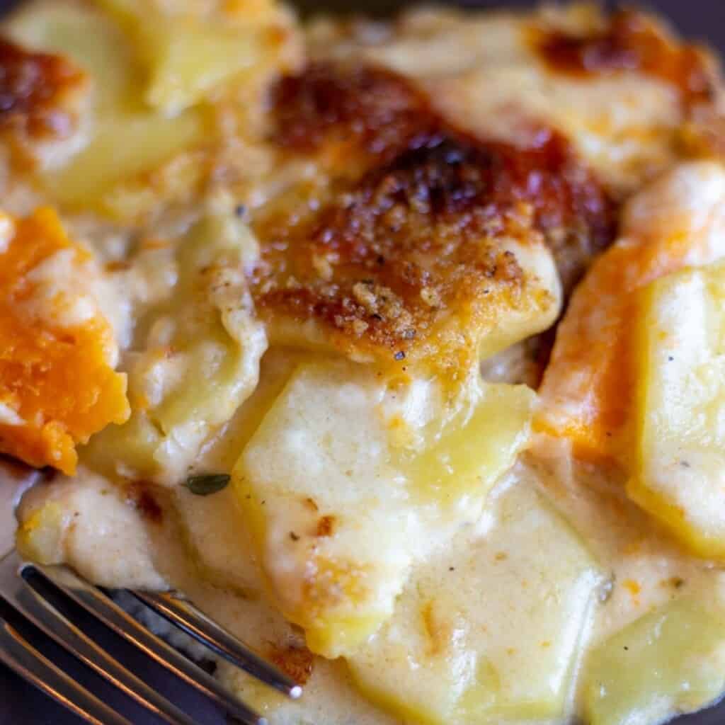 Cheesy scalloped potatoes served on a plate for dinner.
