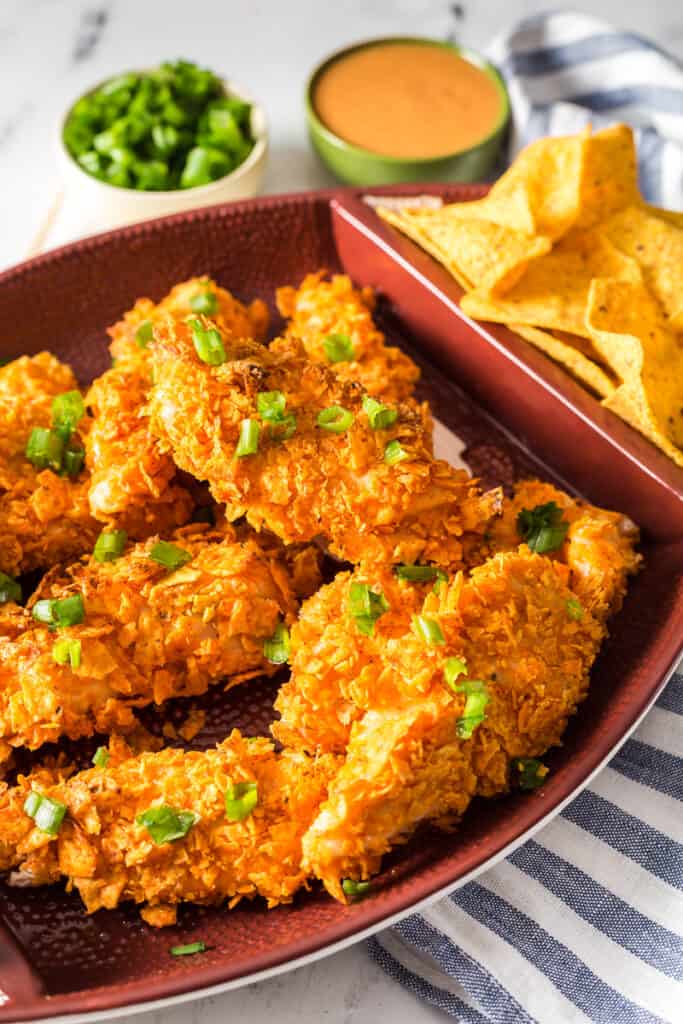 Baked Doritos chicken tenders on brown plate.