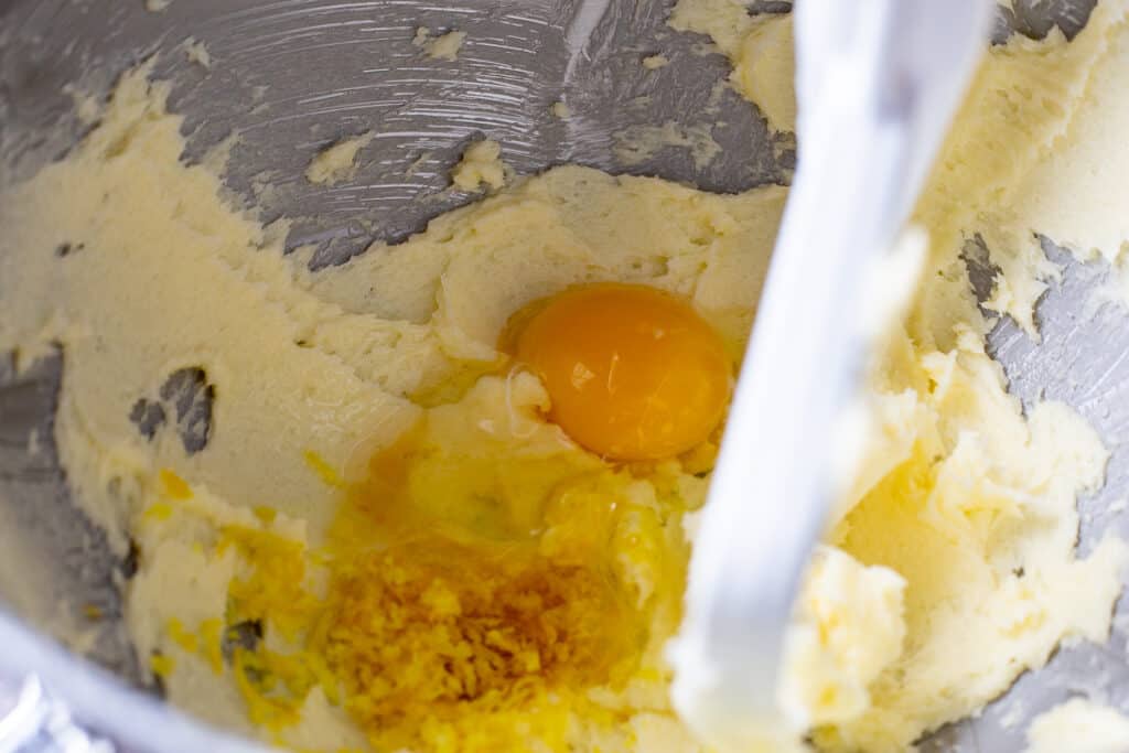 Process photo of adding the egg, vanilla and lemon zest to the other ingredients.