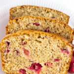 Cranberry banana bread sliced on a white plate.
