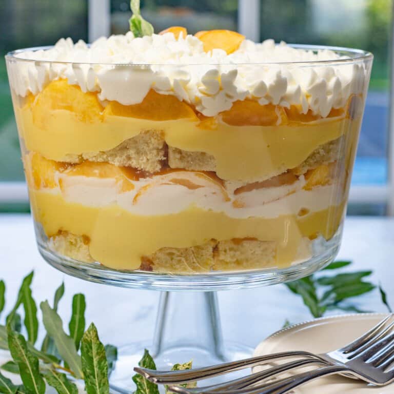 Close up image of fresh peach trifle in glass trifle bowl.