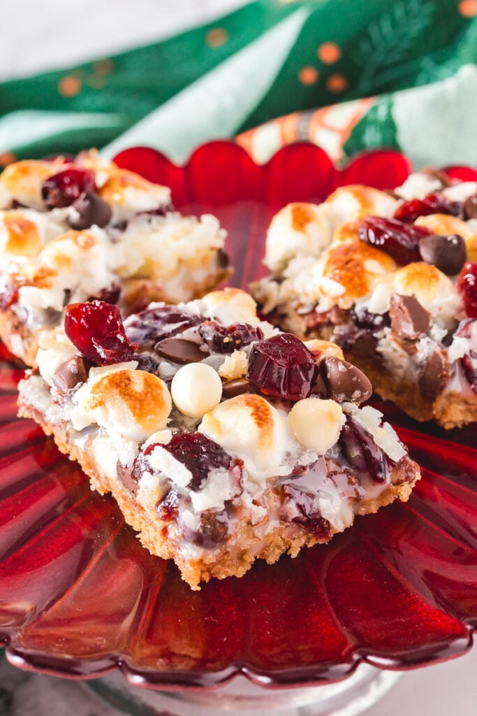 7 layer cranberry magic bars on red plate.