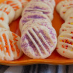 Easy to make buttery Halloween cookies with sprinkles on an orange plate.