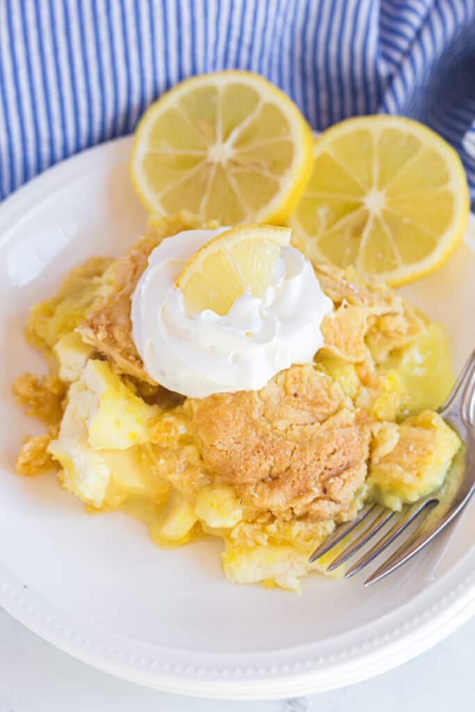 Lemon dump cake with cream cheese served on a white plate.