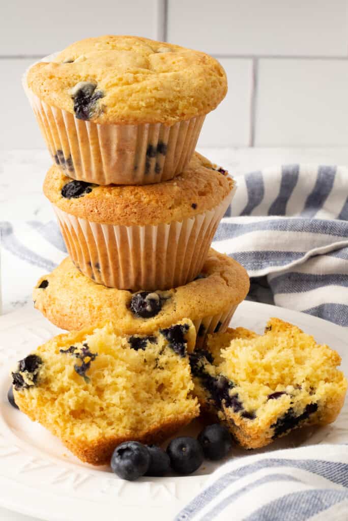 Cake mix blueberry muffins stacked on a white plate.