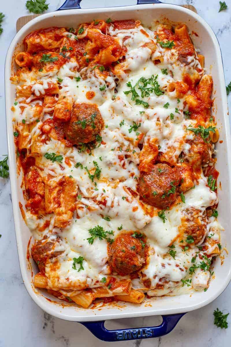 Baked ziti with meatballs in casserole dish.