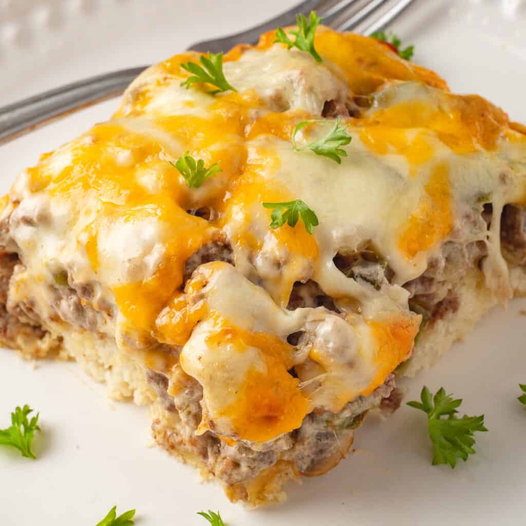 Serving of Philly cheesesteak casserole on a white plate with a fork.