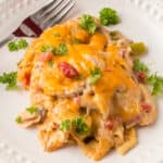 King ranch chicken casserole on a white plate with a fork.