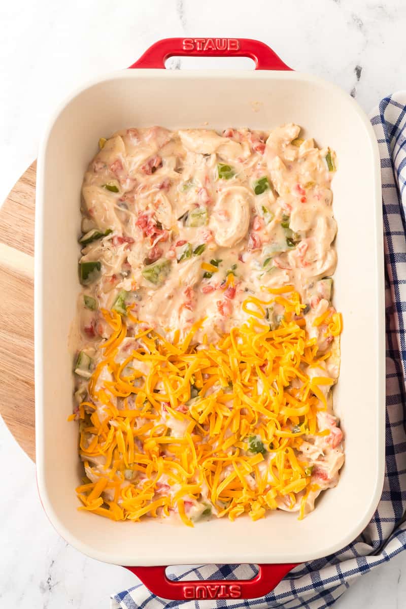 Chicken mixture is added to casserole dish, then covered with cheese.