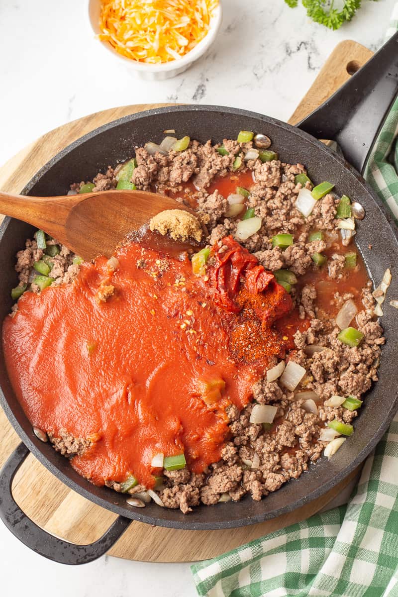 Cooked ground beef with tomato sauce, tomato pasta and spices added to the mixture.