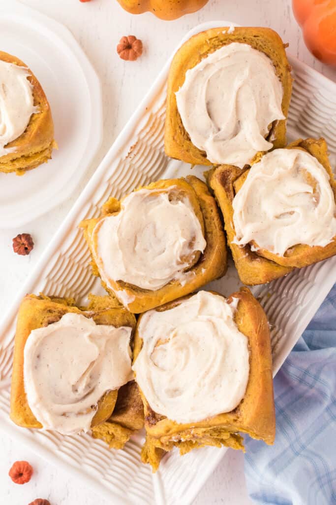 Pumpkin spice cinnamon rolls in a white tray.