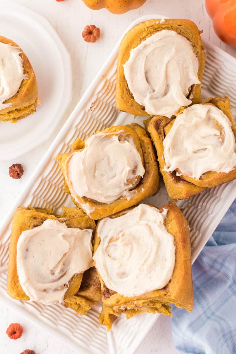 Pumpkin spice cinnamon rolls on a white plate.