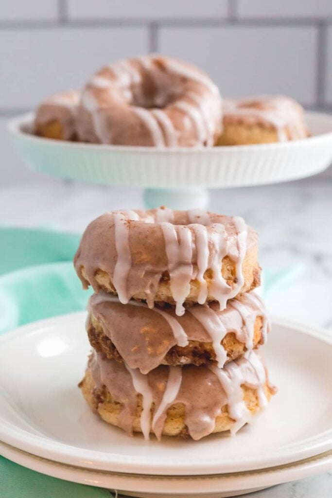Cinnamon roll donuts on a white plate.