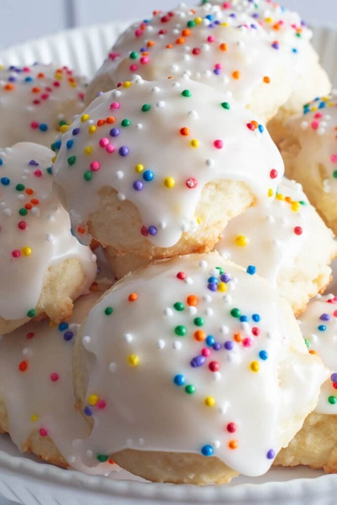 Ricotta cookies with sprinkles on white plate.