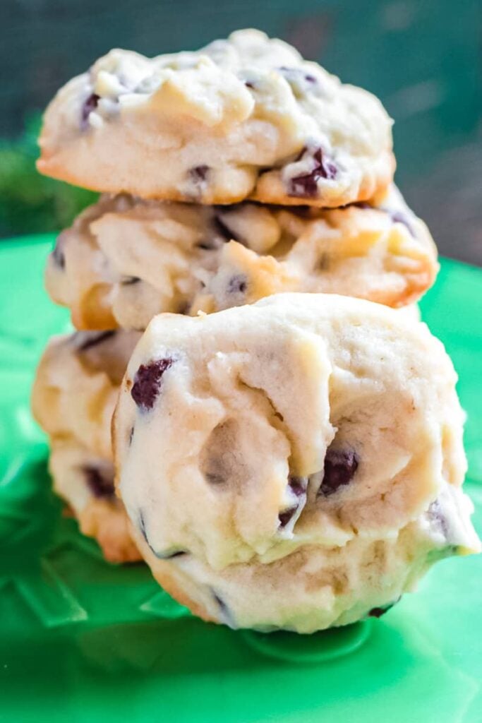 Whipped chocolate chip shortbread stacked on a green serving tray.