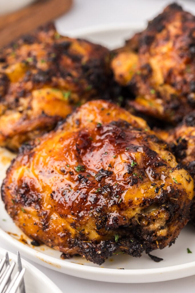 Air fryer chicken thighs on a white plate.
