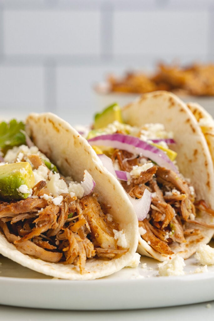 Slow cooker pork carnitas on a white plate.