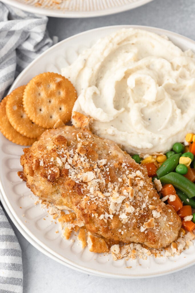Ritz cracker chicken served with creamy mashed potatoes and mixed vegetables.