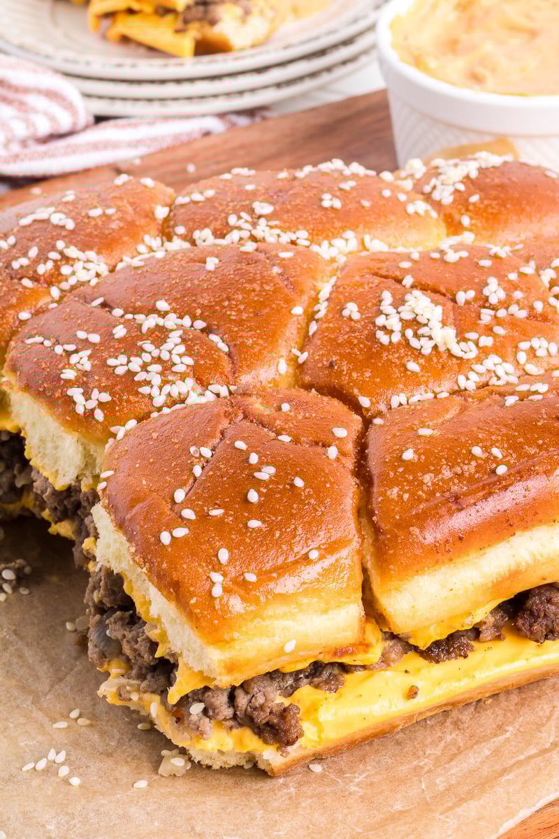 Cheeseburger sliders on wooden serving board.