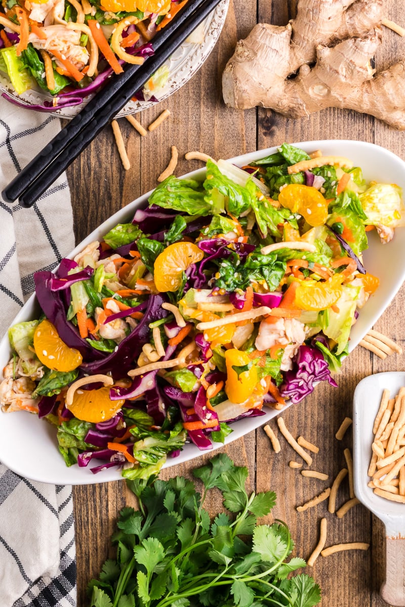 Overhead view of white chicken salad on a white oval platter.