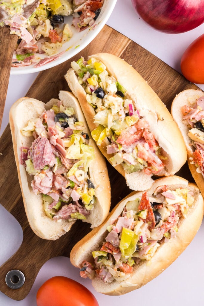 Chopped Italian sandwiches on wooden board.
