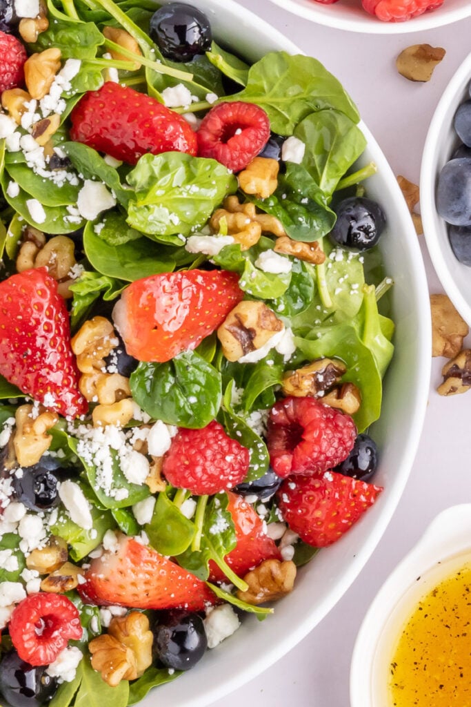Strawberry spinach salad in a white bowl.