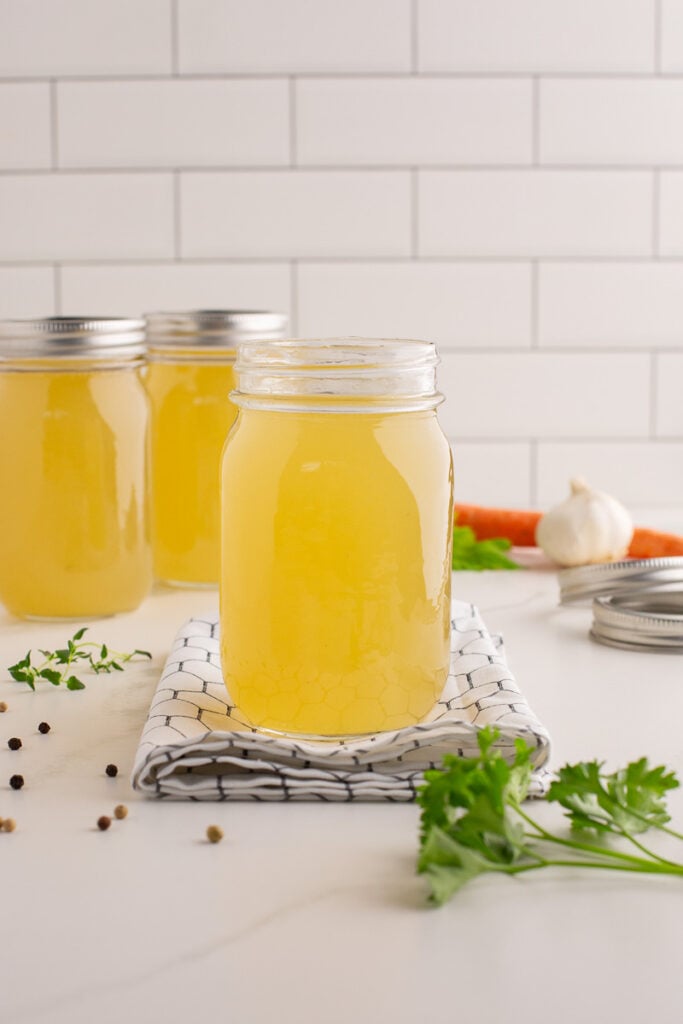 Homemade soup broth in a glass jar.