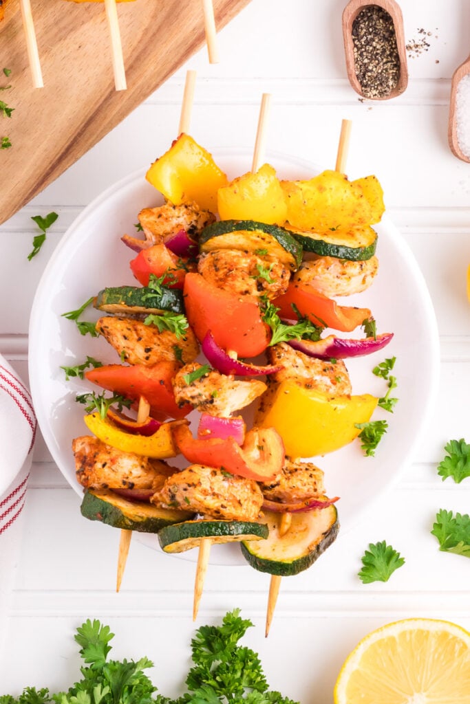 Oven baked chicken kabobs on a white plate.