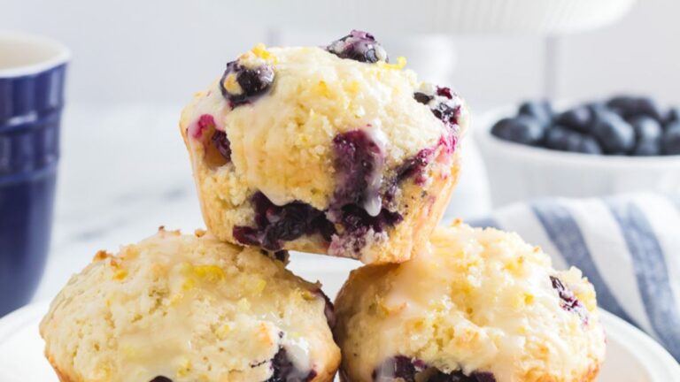 Lemon bluberry muffins stacked on a white plate.