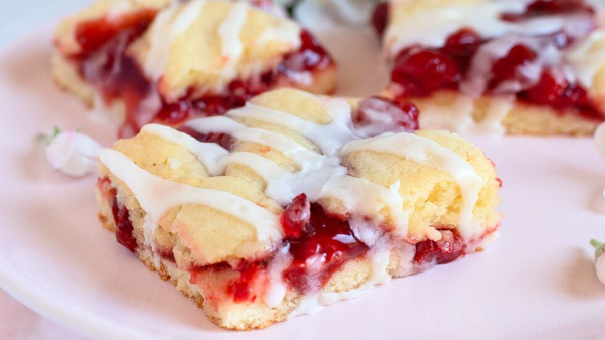 Cherry pie bars on a pink plate.