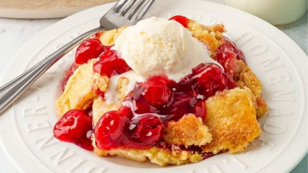 Cherry pineapple dump cake served on a white plate.