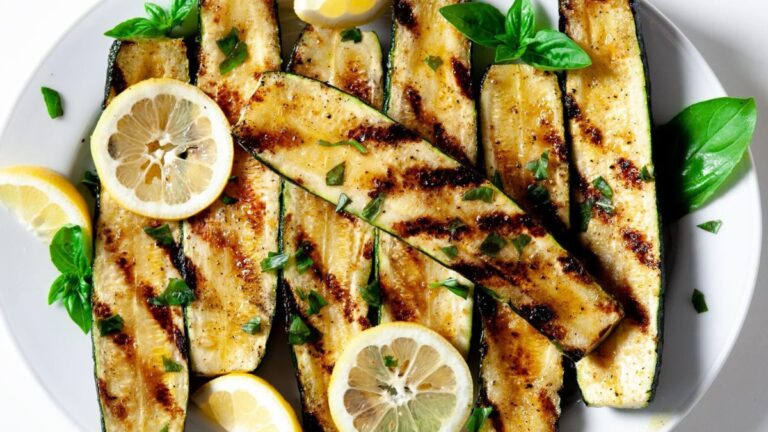 Grilled zucchini on a white plate.