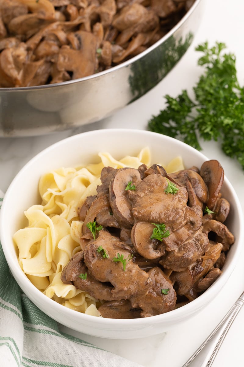 Beef stroganff with noodls in a white bowl.