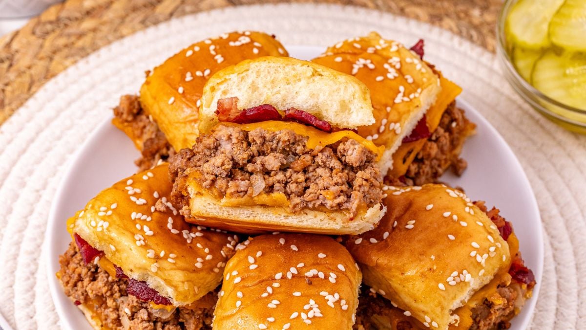 Cheeseburger bacon sliders on a white plate.
