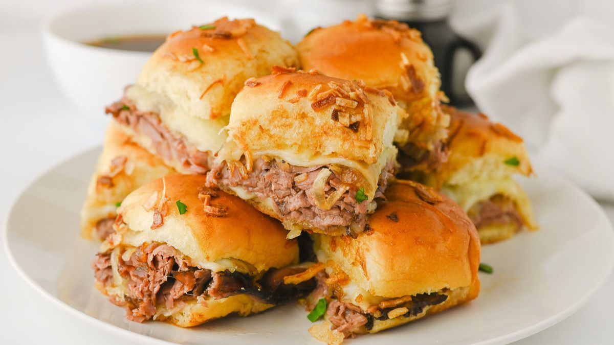 French dip sliders on a white plate.