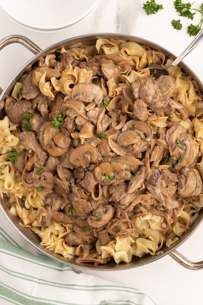 Overhead picture of beef stroganoff and egg noodles in a pan.