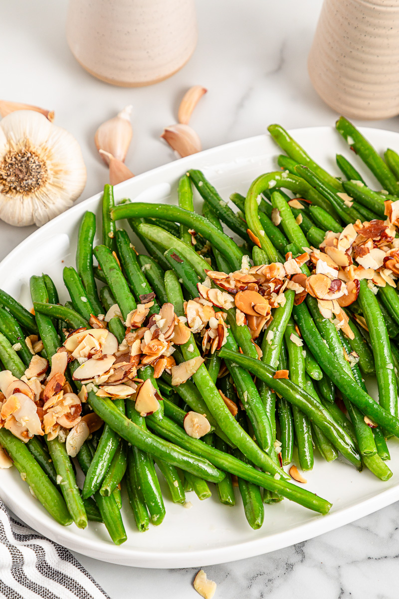 Green beans almondine served on a white plate.