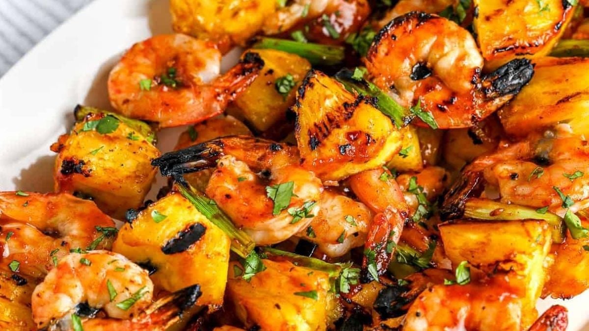 Close up image of shrimp kebabs on a white plate.