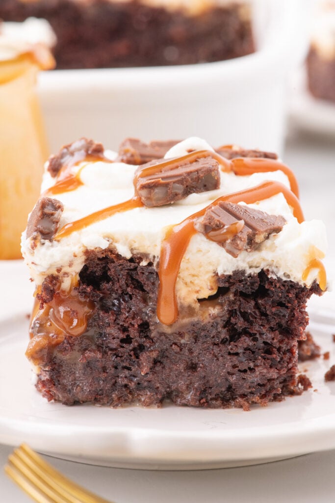 Better than anything cake served with caramel sauce on a white plate.