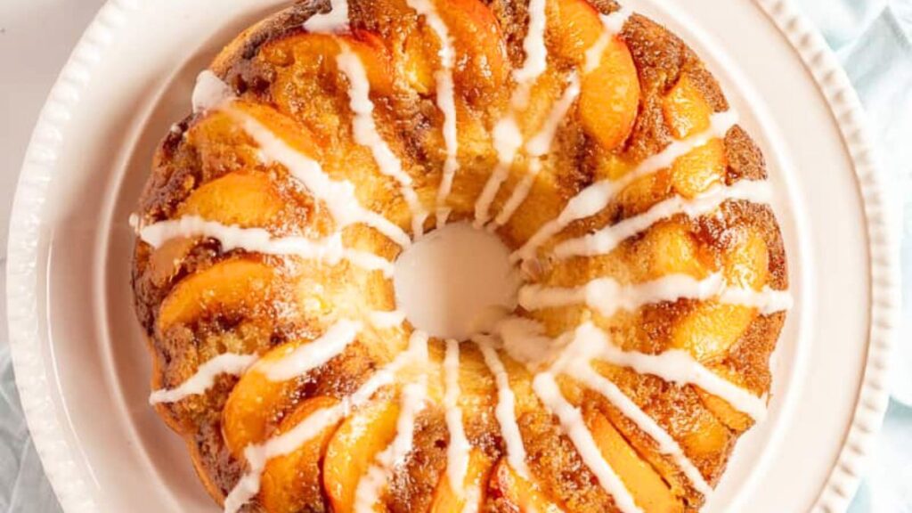 Peach cobbler bundt cake on a white plate.