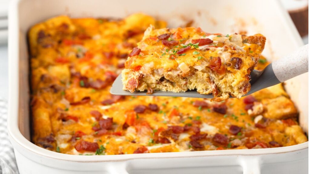 Bacon egg and cheese breakfast casserole in a white casserole dish.