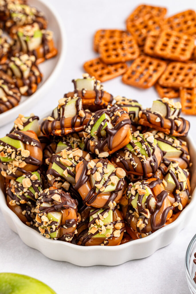 Caramel apple pretzel bites in a white bowl.
