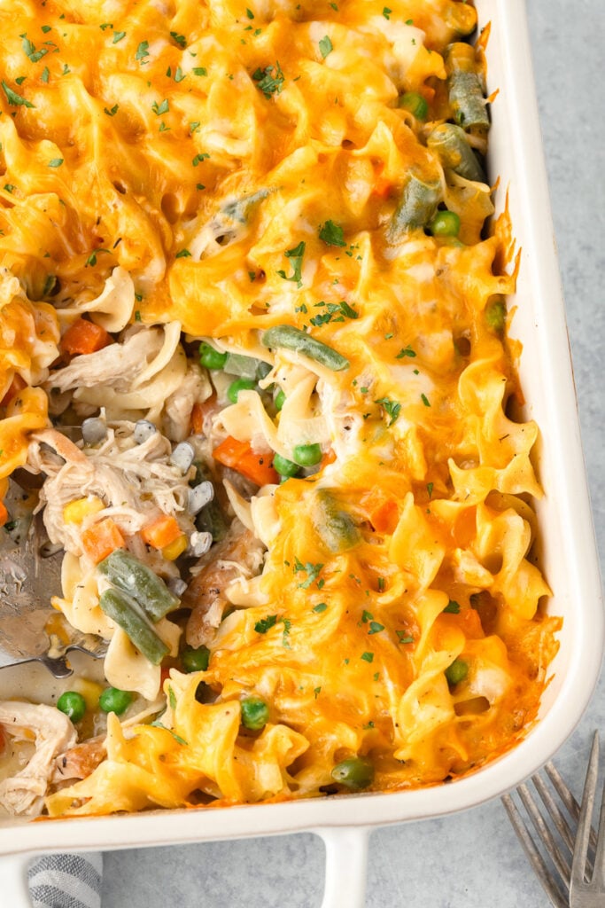 Chicken egg noodle casserole with a piece missing from the dish.