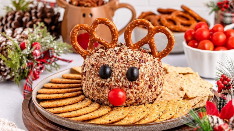 Reindeer cheese ball served on a plate with crackers.