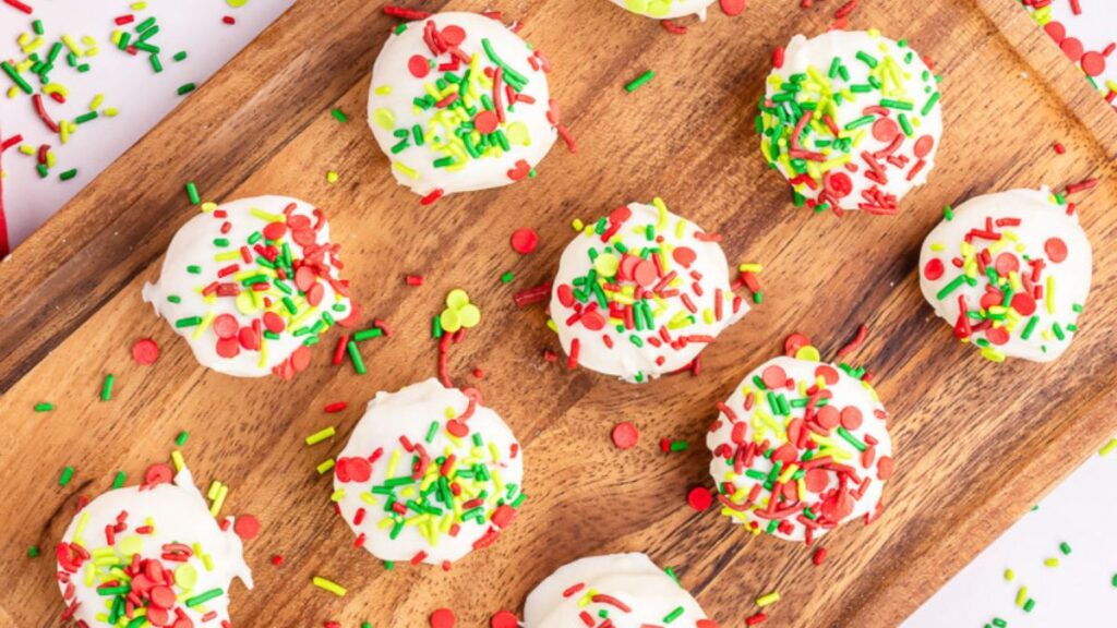 Sugar cookie truffles on a wooden board.