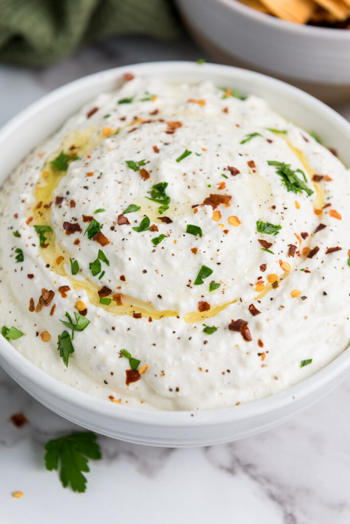 Feta dip appetizer in a white bowl perfect for a holiday party.
