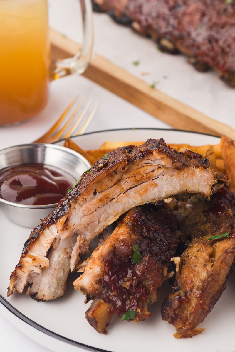 Oven baked ribs on a white plate.