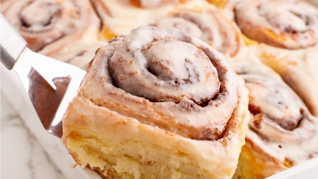 Cinnamon rolls scooped on a serving spoon.